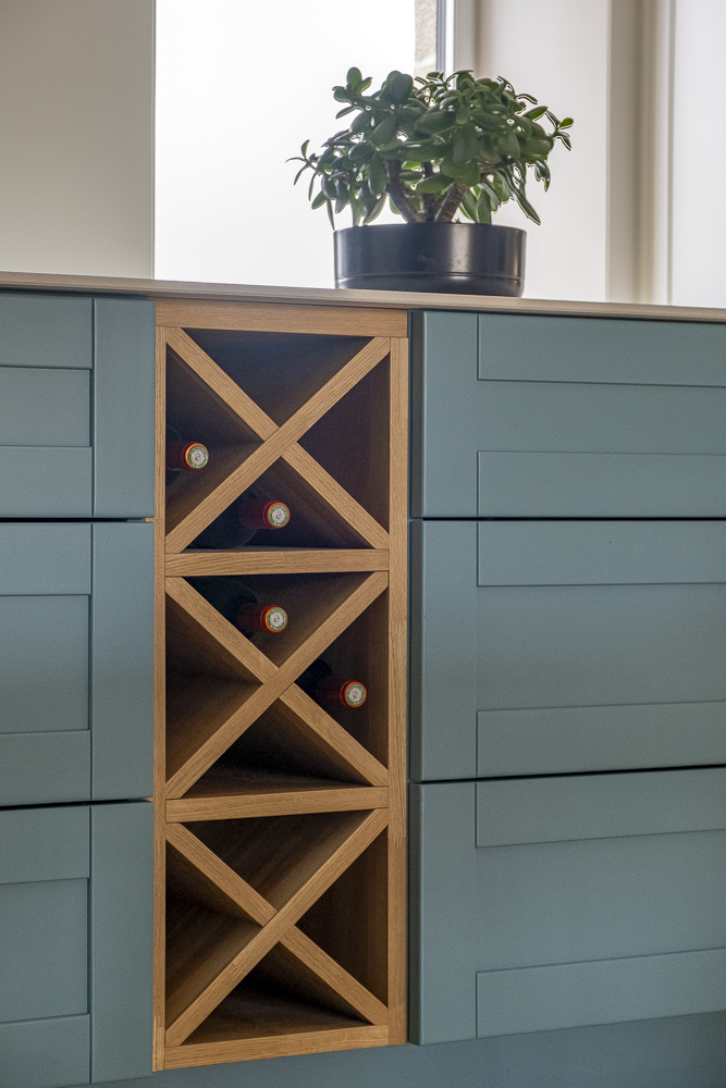 Étagère en bois pour bouteilles intégré au mobilier de cuisine.