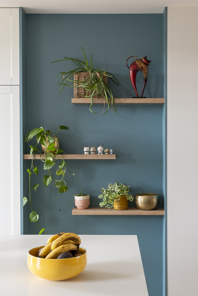 Niche bleue et étagères en bois dans le mobilier de cuisine